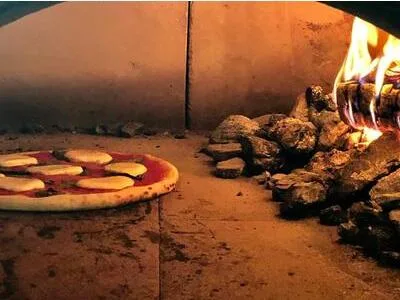 Pizza baking in the coal-fired oven